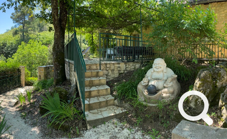 Terrasse à l'ombre de la glycine de la Boetie avec coin repas et salon de jardin.